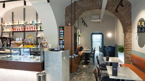 Un restaurante con zona de bar, mesas y vistas a través de un arco.