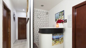 Un área de recepción con un mostrador de madera, una pared con diseño y un reloj.