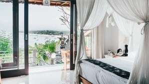 Un dormitorio con cama, mesita de noche y vistas a un paisaje urbano a través de un amplio ventanal.