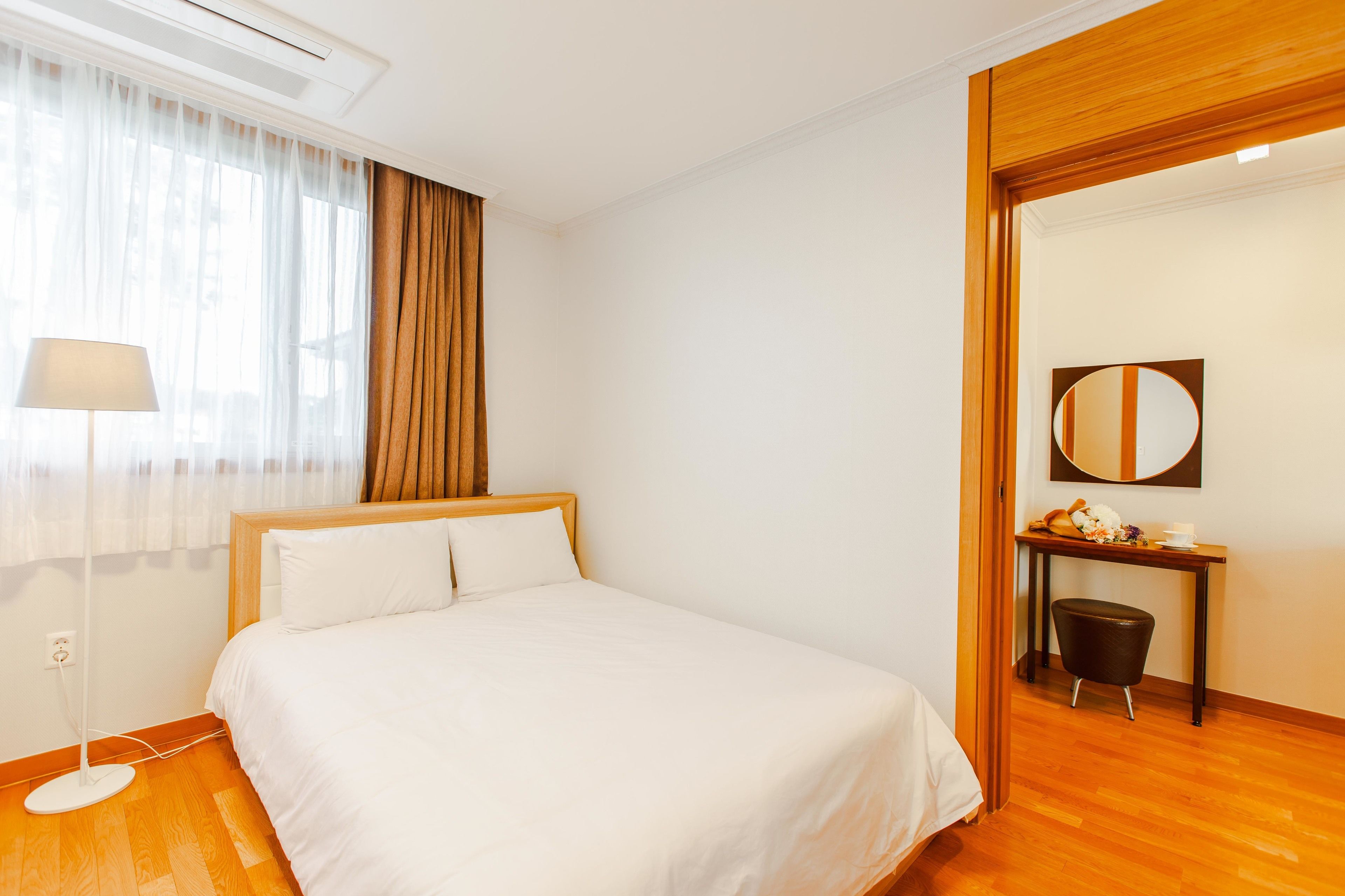 Habitación de hotel ordenada con cama, escritorio y silla.