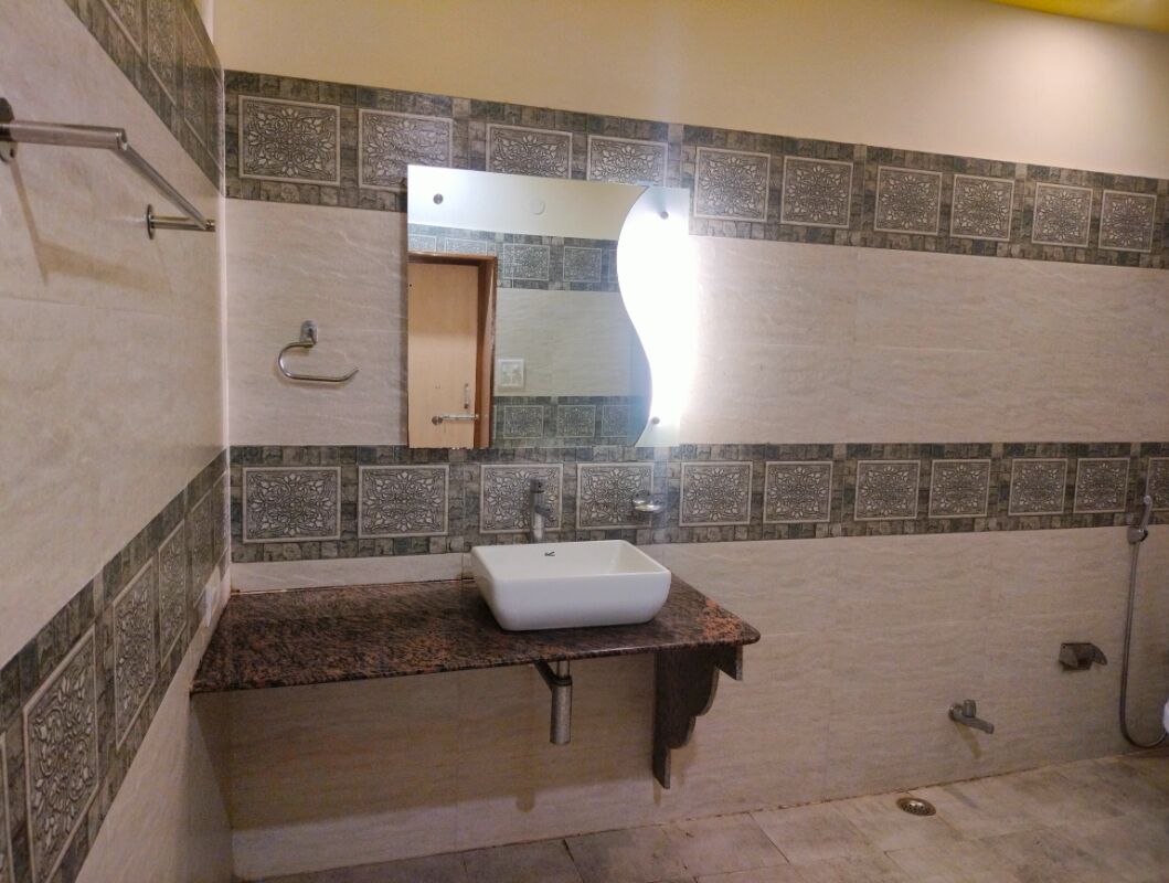 A bathroom with a white sink, a mirror, and a shower area.