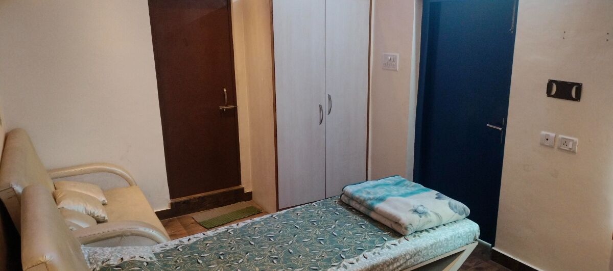 Un dormitorio con cama, armario y puerta.