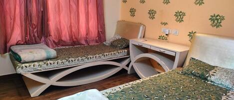 Una habitación con dos camas, un escritorio y una silla.