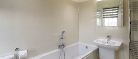 A modern bathroom with a bathtub, a sink, and a toilet.