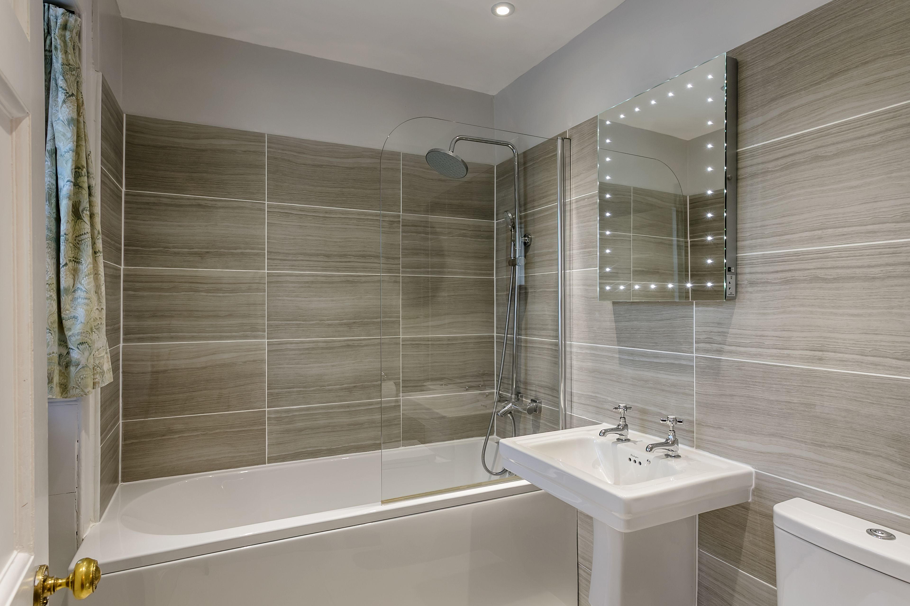 A modern bathroom with a bathtub, a sink, and a toilet.