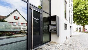 A hotel entrance with a glass door labeled "EINGANG" and a payment machine on the right. - RiKu HOTEL Weissenhorn (Weissenhorn)
