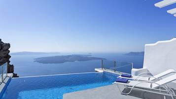 Une piscine à débordement offrant une vue sur la mer et les îles.