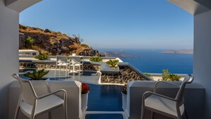 A terrace with a view of the sea, white chairs, and potted plants. - Pegasus Suites & Spa (Santorini)