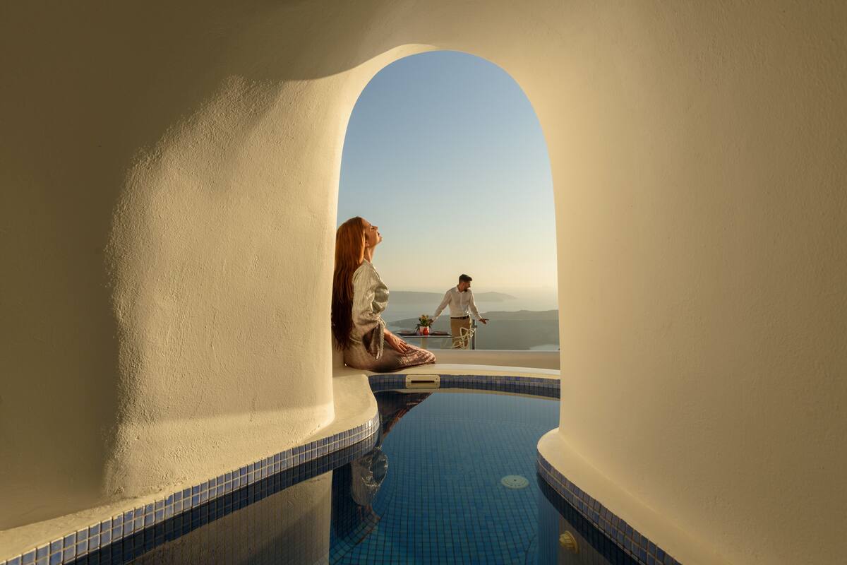 A pool with a clear view of the sky and a person meditating.