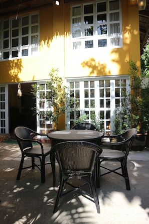 A yellow building with a patio area featuring a table and four chairs.