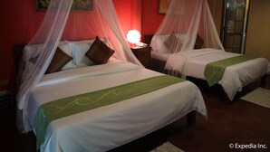 Two beds with white linens and green accents, a bedside table with a lamp, and a red wall with a framed picture. - The Sun Villa Resort and Spa Hilltop (Boracay Island)