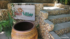 A sign for 'Sun Villas' with a sun emblem, surrounded by stone steps and greenery. - The Sun Villa Resort and Spa Hilltop (Boracay Island)