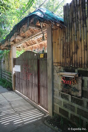 A wooden structure with a bamboo fence and a sign that reads "Sun House Spa."