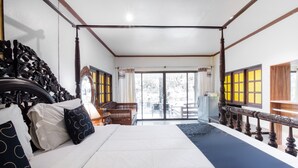 Un dormitorio con una cama grande, cabecera de madera y balcón con vistas.