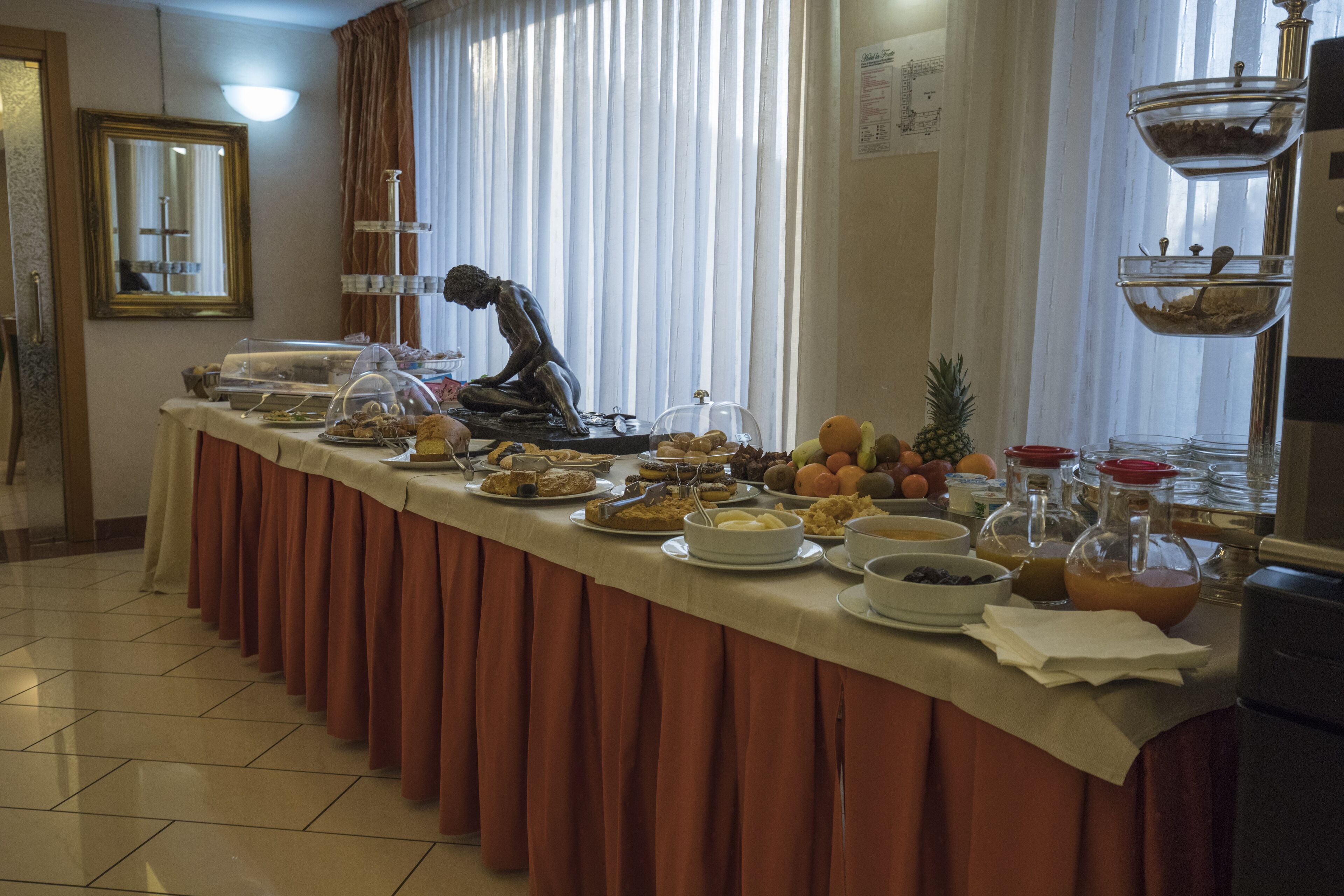 Ein reichhaltiges Buffet mit Speisen und einer Skulptur.
