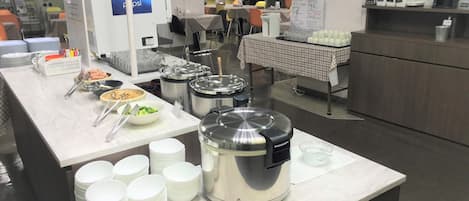 A buffet setup with various food items and serving utensils.