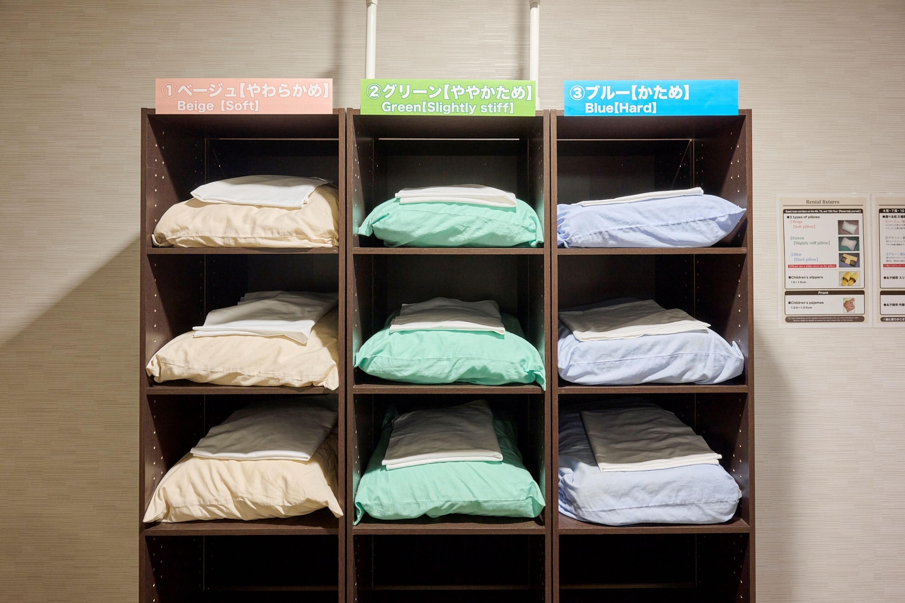 A set of shelves with labeled bedding options in a hotel room.