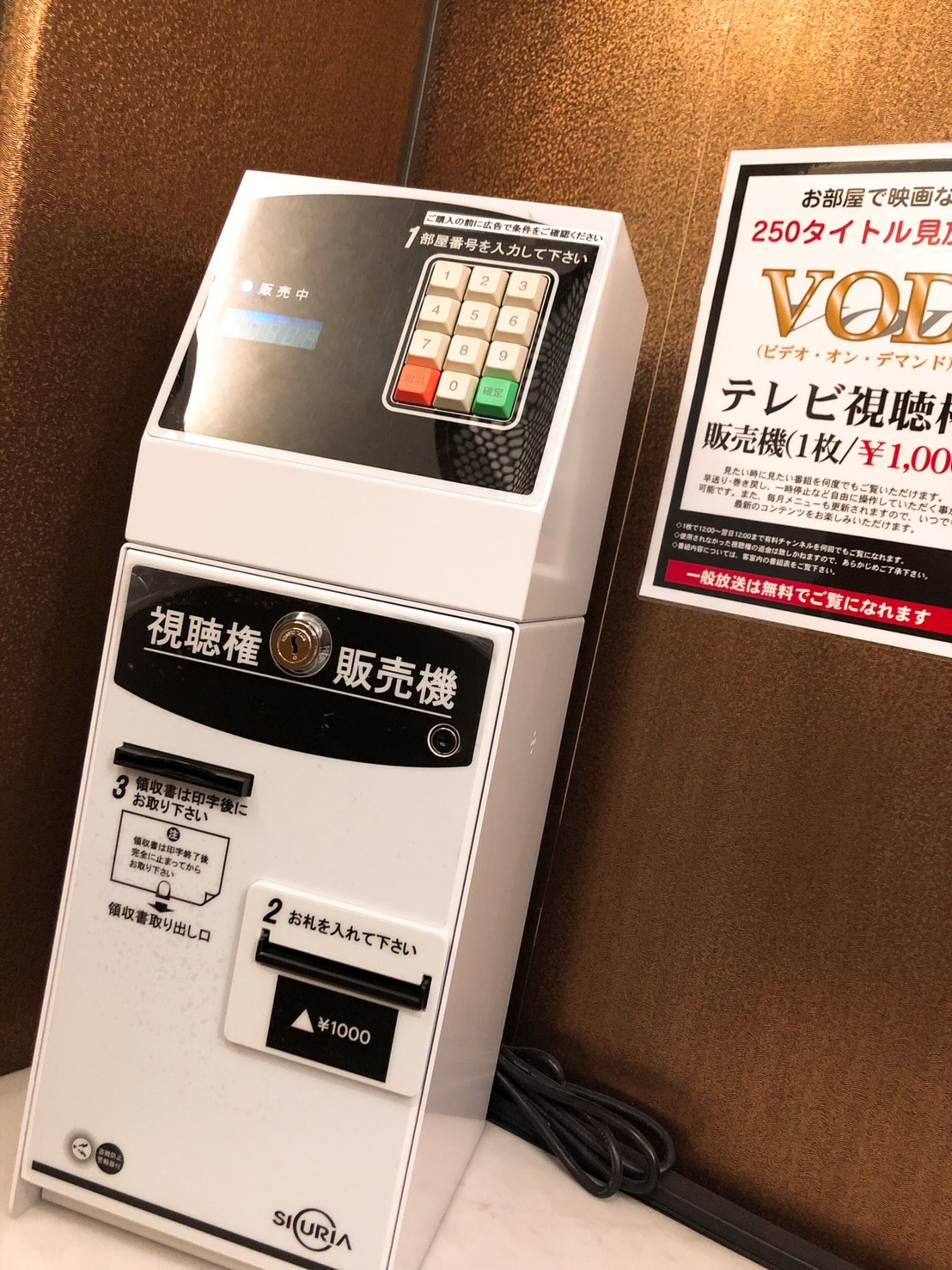 Un distributeur de billets avec des instructions en japonais, un lecteur de cartes et un compartiment pour les pièces de monnaie.
