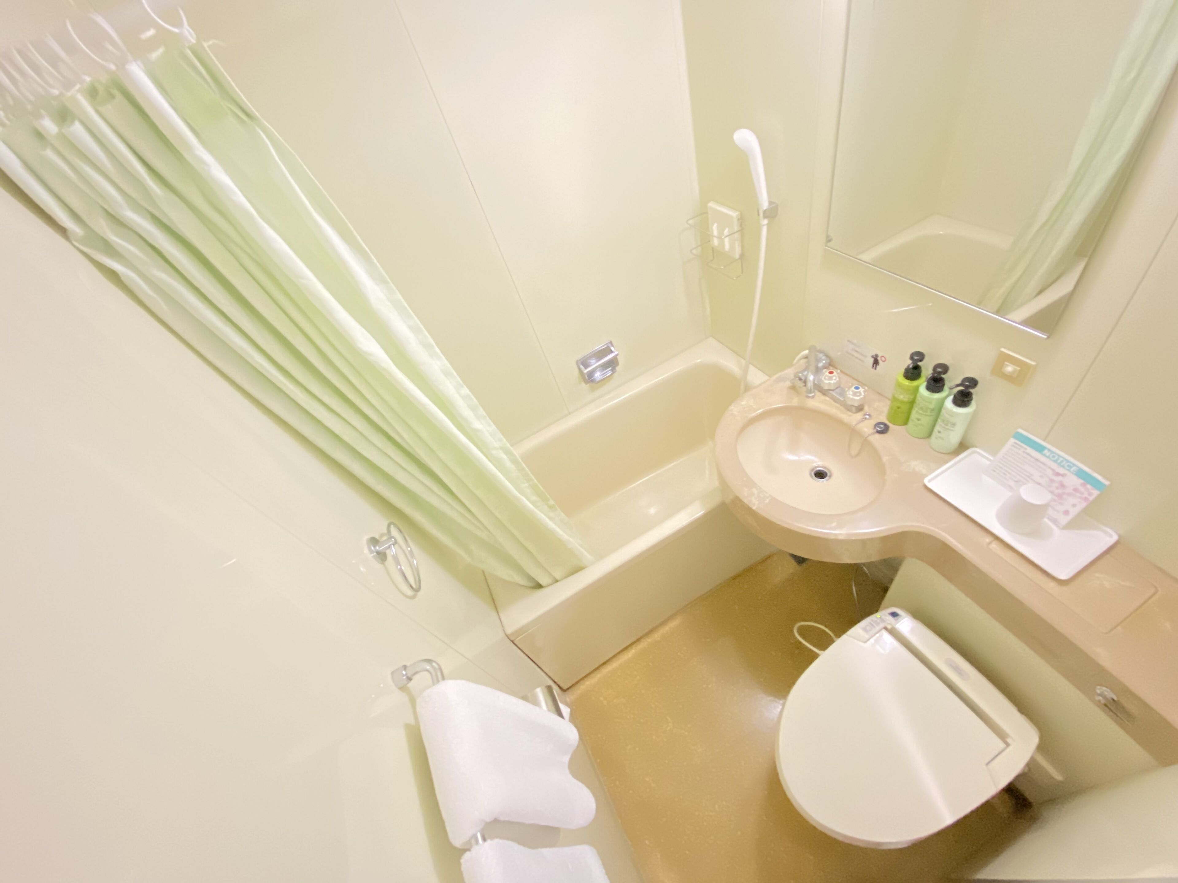 Un baño con bañera, lavamanos, inodoro y espejo.