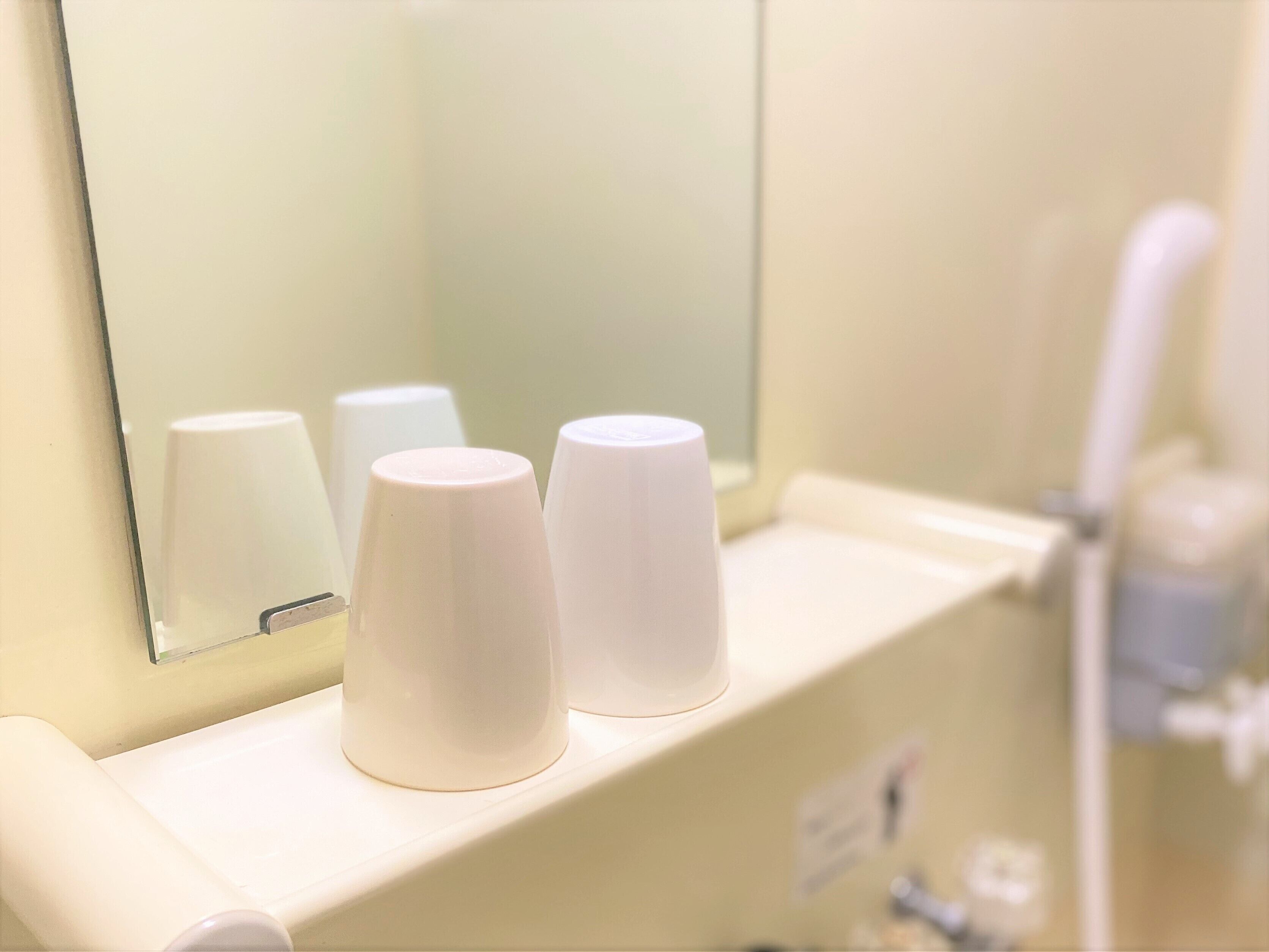 Un baño con tres dispensadores de toallas de papel blancas sobre una encimera.