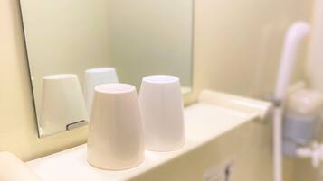 A bathroom with three white paper towel dispensers on a counter.