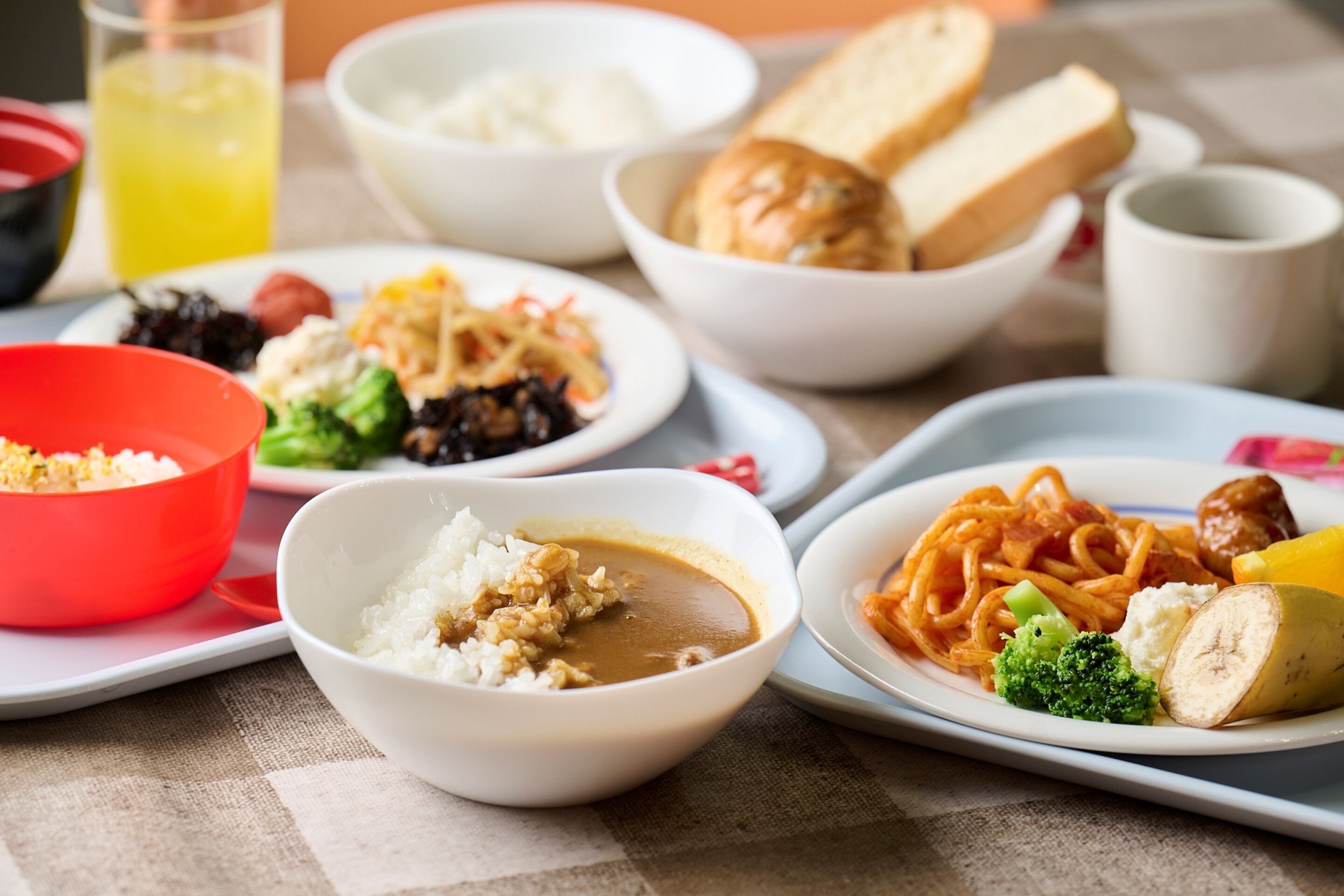 A table with various dishes including rice, noodles, and vegetables.