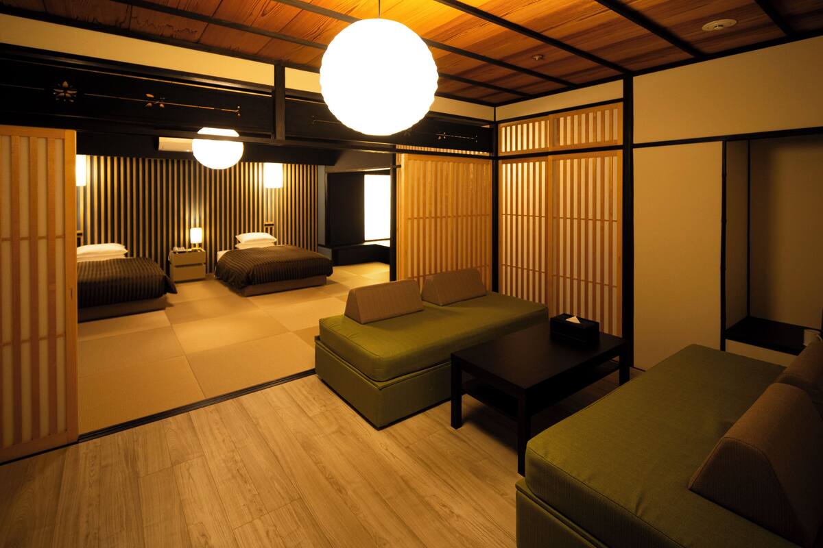 Une pièce de style japonais traditionnel, avec un sol recouvert de tatamis, de petites tables basses et des portes coulissantes.