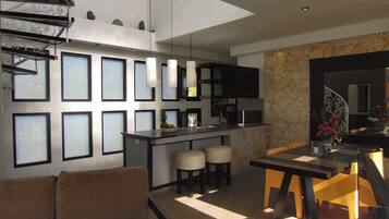 Una cocina moderna con una isla central, taburetes de bar y un área de comedor con mesa y sillas.