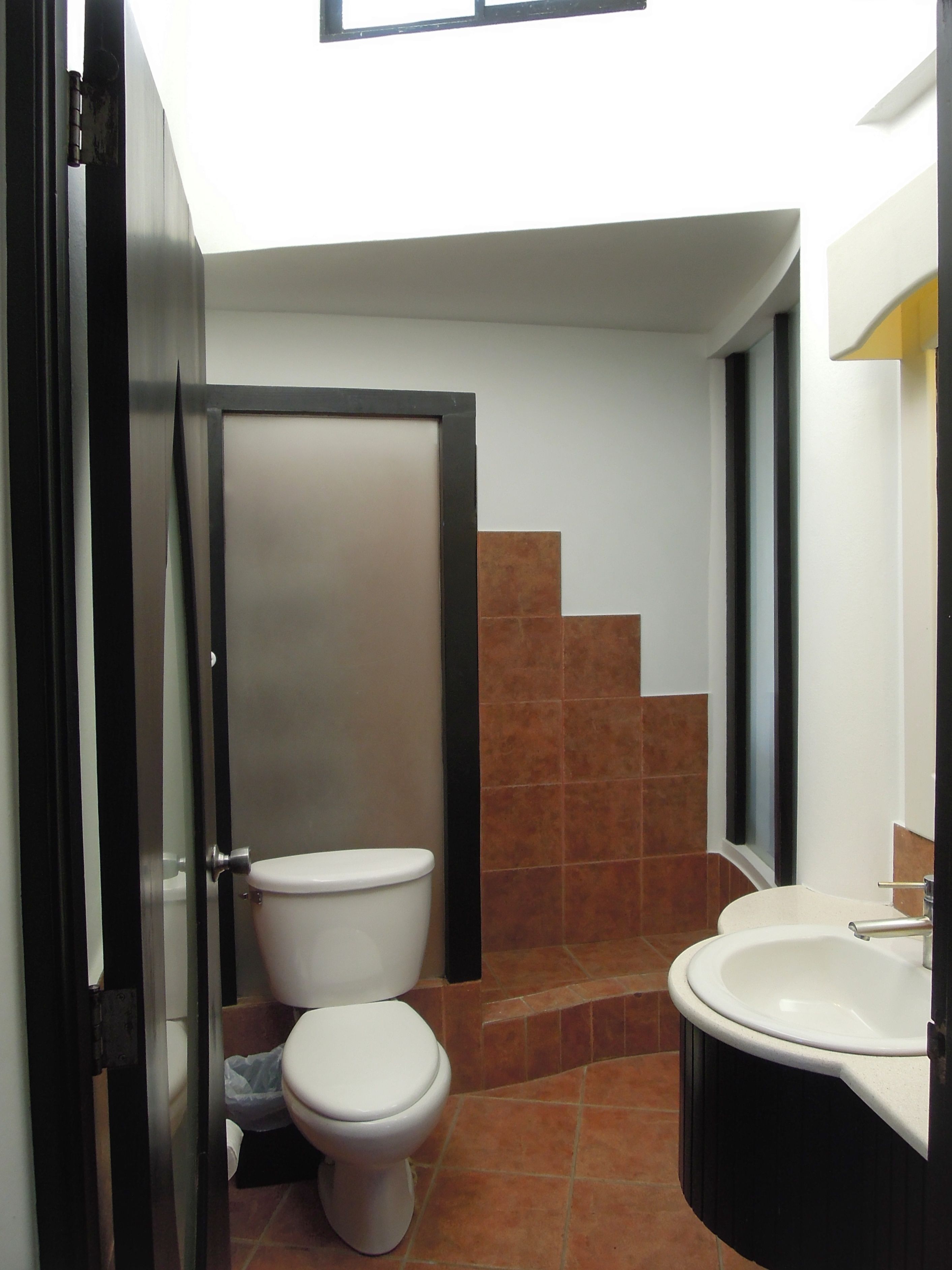 Ein kleines Badezimmer mit Toilette, Waschbecken und Duschbereich.