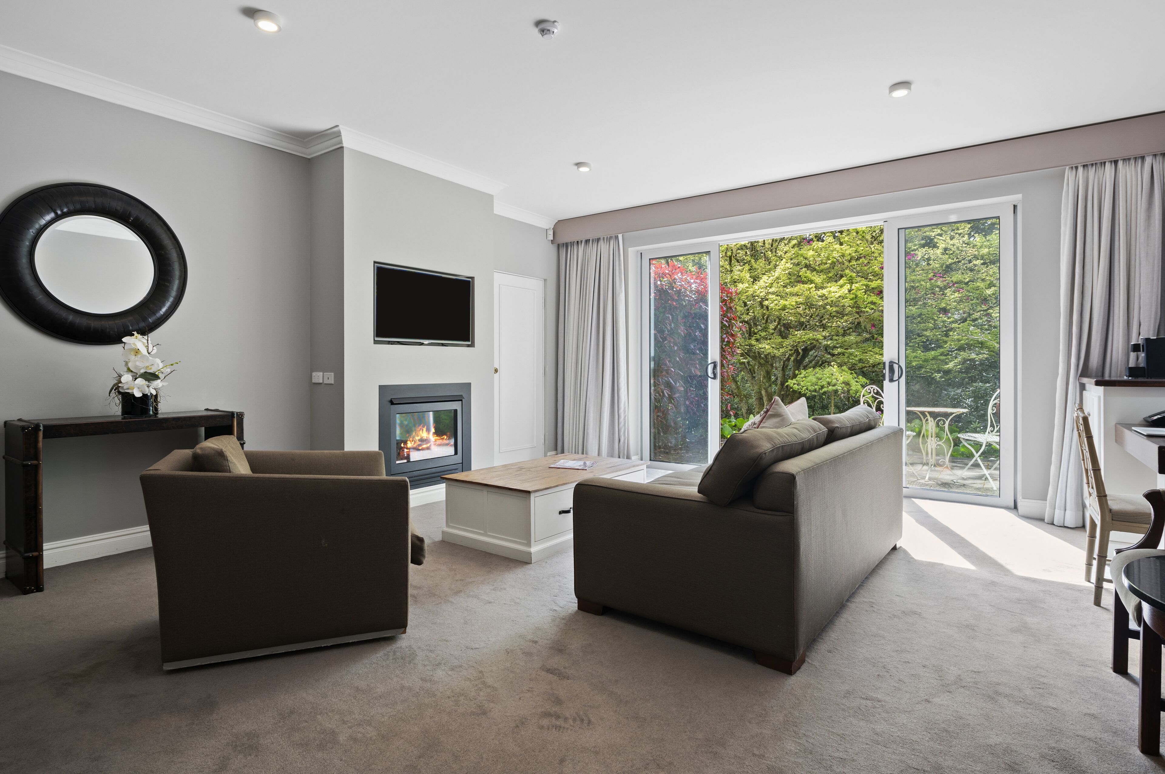 Una sala de estar moderna con chimenea, dos sofás, una mesa de centro y un televisor.