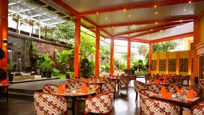 Un restaurant doté d’une salle à manger intérieure, d’un mur en pierre et d’une cascade décorative.