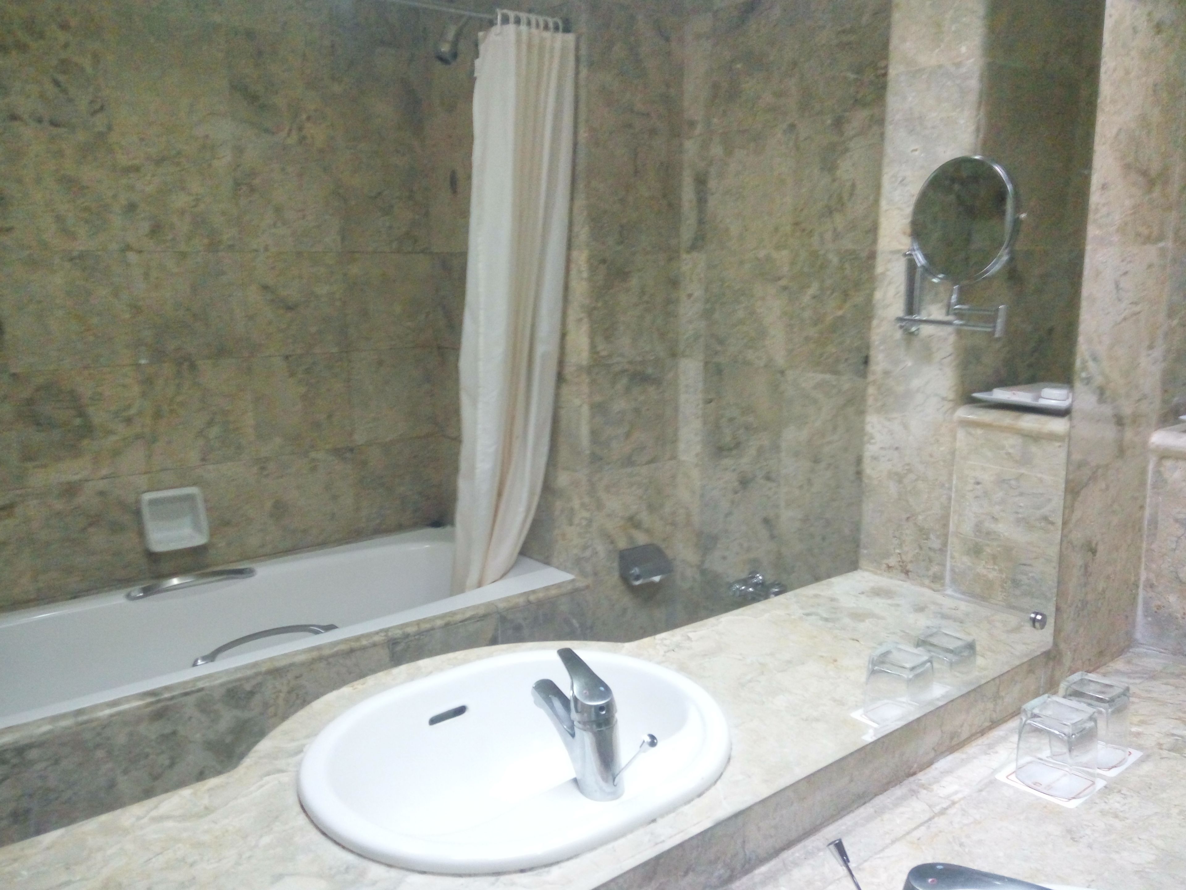 Un baño con bañera, lavamanos, ducha y espejo.