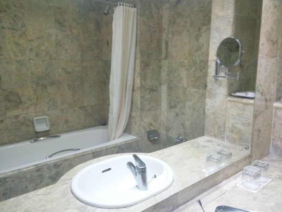 Un baño con bañera, lavamanos, ducha y espejo.