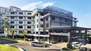 Un hôtel doté d’une façade moderne, de nombreux balcons et d’une entrée sécurisée par un portail.