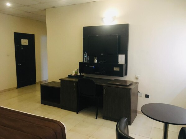 A hotel room with a desk, chair, and a small table. - Atlantic Hotels and Suites (Lagos)
