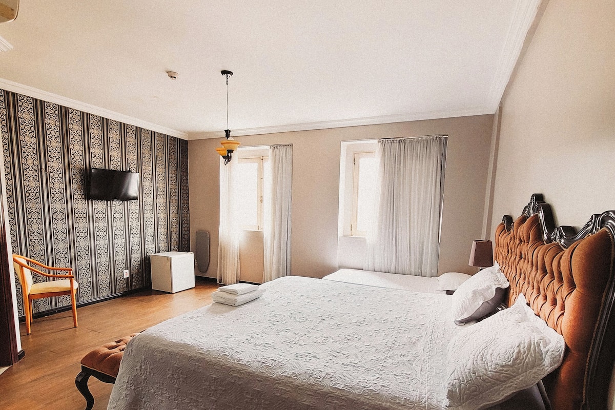 Escritorio, cortinas blackout y tabla de planchar con plancha