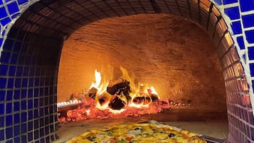 Ein Pizzaofen mit blau gefliestem Innenraum und einer Pizza darin.