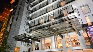 A modern hotel with multiple floors, large glass windows, and a well-lit entrance. - Amari Dhaka (Dhaka)