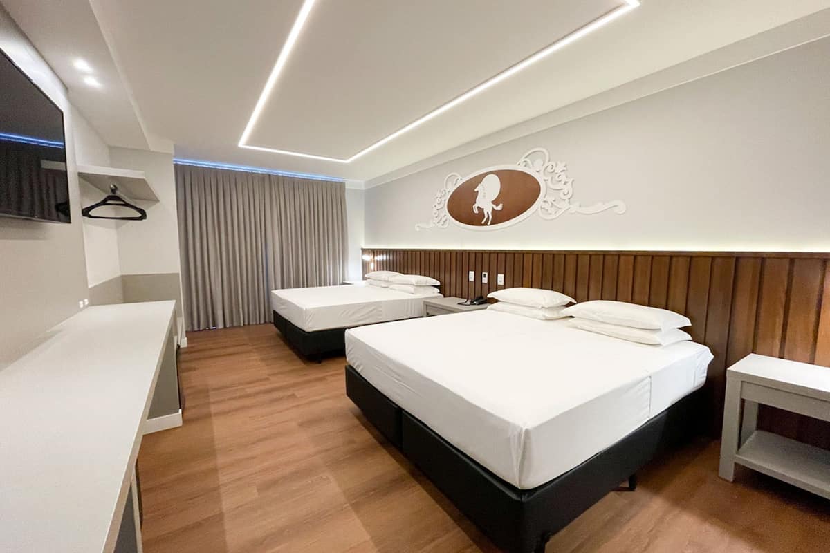 A modern hotel room with two beds, a desk, and a mirror.