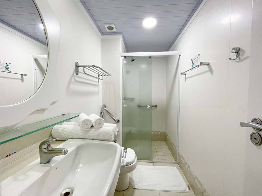 Un baño moderno con un lavamanos grande, inodoro y cabina de ducha con paredes de vidrio.