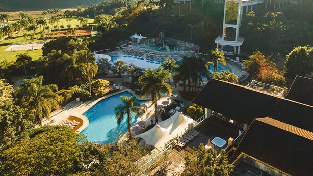 Un resort con varias piscinas, un tobogán acuático y un edificio grande con una torre.