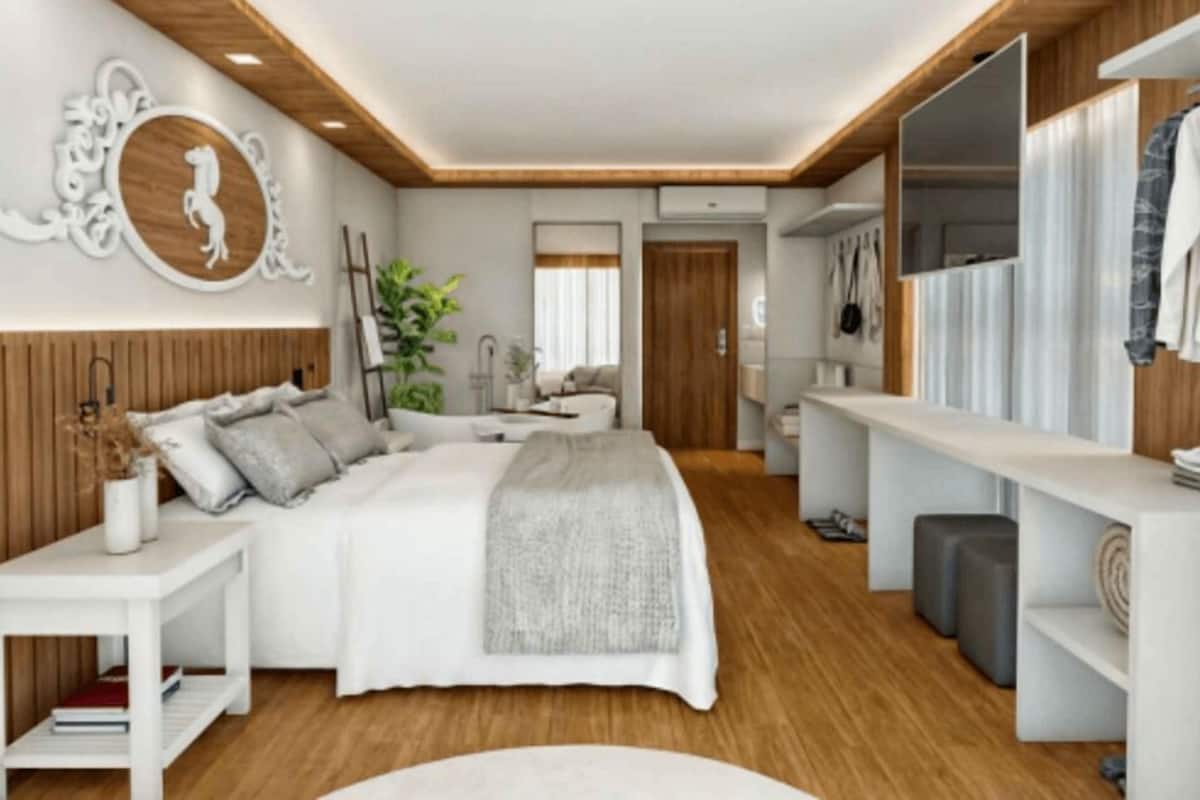 A modern bedroom with a large bed, a bedside table, a mirror, and a wardrobe.
