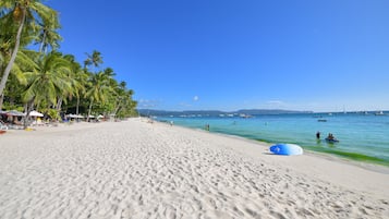 On the beach, white sand, sun-loungers, beach towels