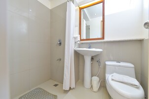 Un baño con ducha, lavabo, inodoro y un espejo sobre el lavabo.