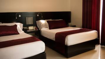 A hotel room with two beds, a nightstand with a lamp, and a red curtain.