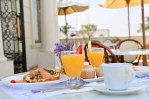 A breakfast setting with a plate of food, a glass of orange juice, and a cup on a table. - Grand Hotel, Hotel Boutique Tepatitlán (Tepatitlan de Morelos)
