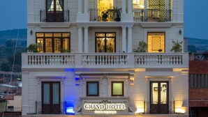 Um hotel de vários andares com varandas, janelas grandes e uma placa com a inscrição 