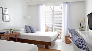 A modern hotel room with a bed, bedside table, lamp, TV, and a view of the outdoors through large windows. - Blue Marina (Boracay Island)