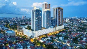 A high-rise building complex with multiple skyscrapers, surrounded by residential houses.