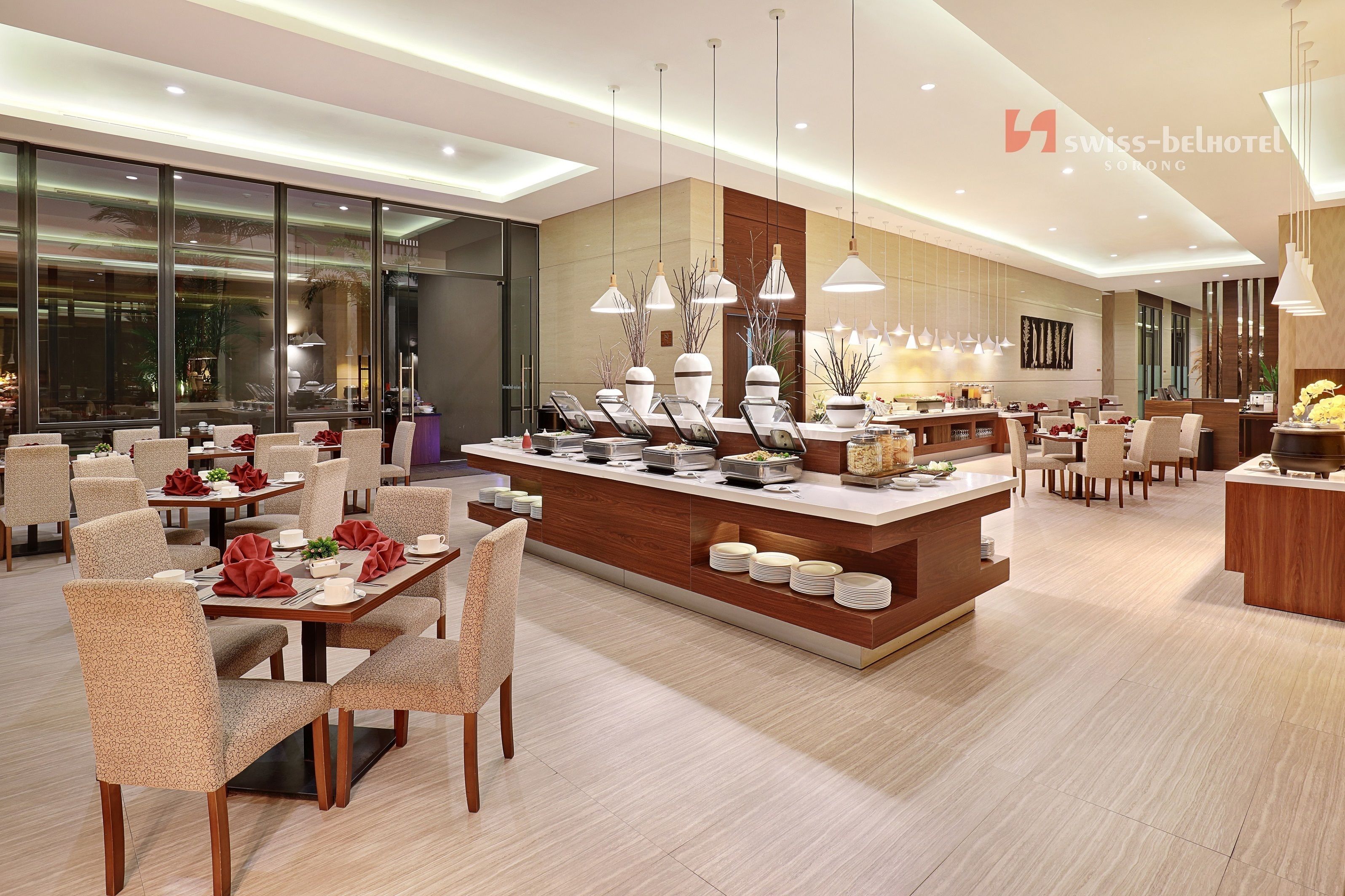 A modern hotel lobby with a central island, seating areas, and large windows.
